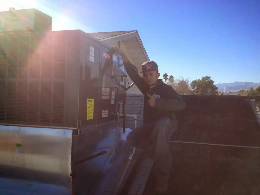 HVAC technician performing AC Tune-Up on a rooftop unit in Snyder